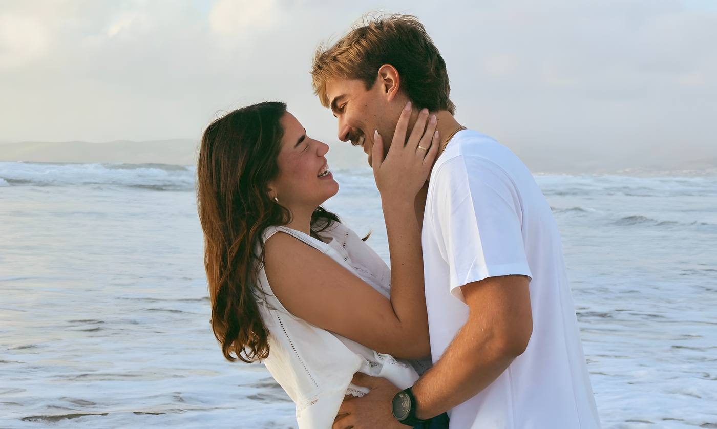 Couple embracing at the shoreline during golden hour